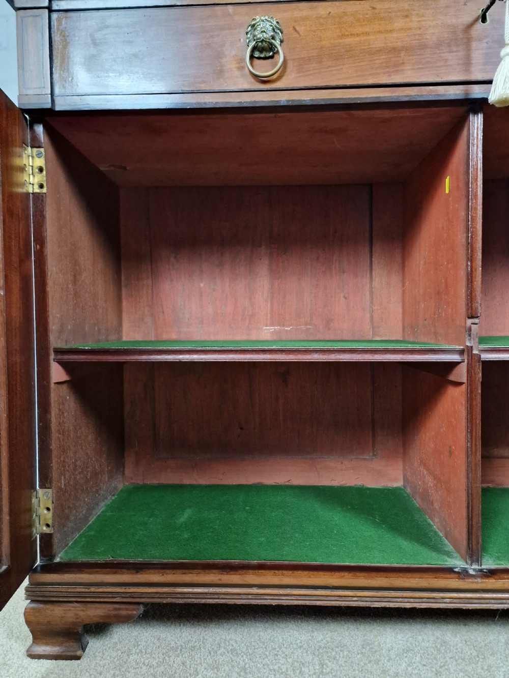 A George IV mahogany bookcase cupboard featuring glazed upper doors with Gothic arch glazing bars above a lower panelled cupboard. View XI