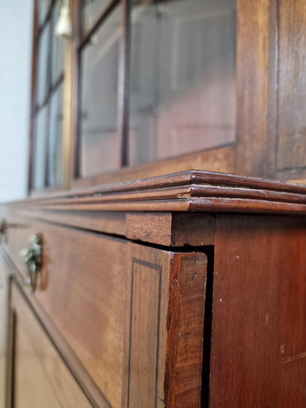 A George IV mahogany bookcase cupboard featuring glazed upper doors with Gothic arch glazing bars above a lower panelled cupboard. View XIV
