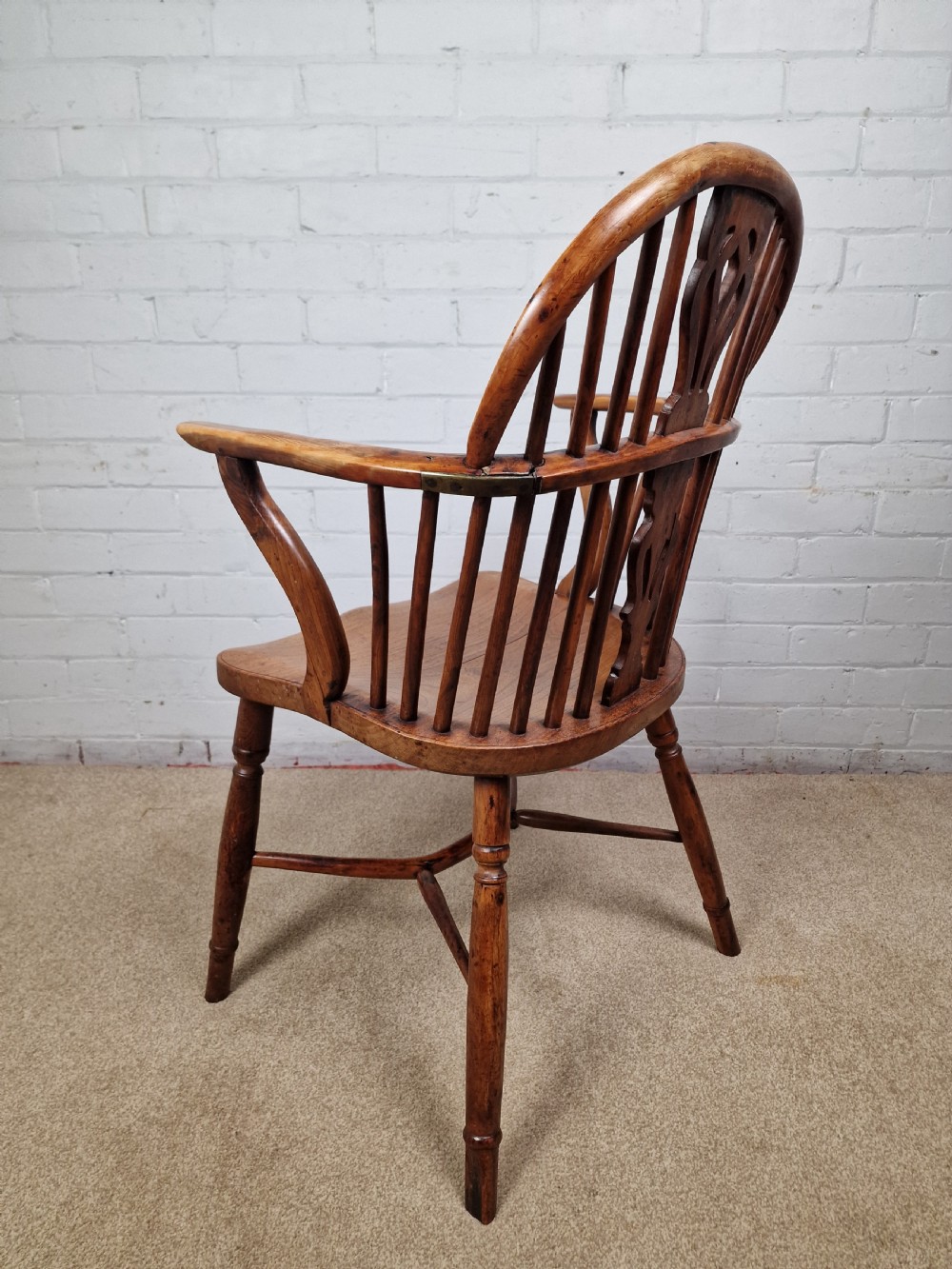 An early nineteenth-century Windsor armchair crafted from yew and elm, featuring a hoop back, pierced central splat, turned legs, and a curved crinoline stretcher. View VI