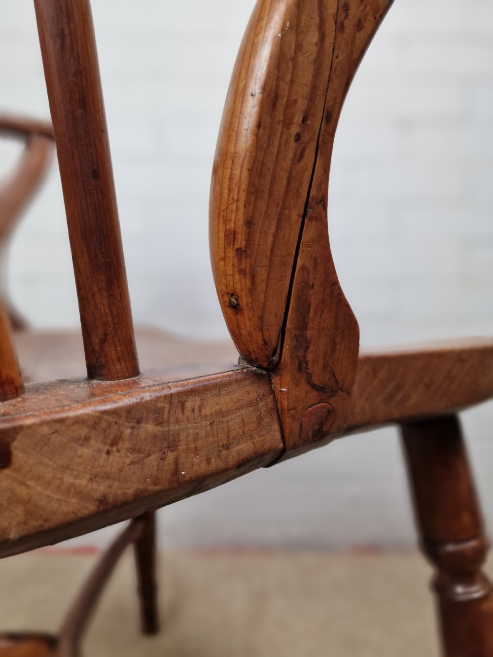 An early nineteenth-century Windsor armchair crafted from yew and elm, featuring a hoop back, pierced central splat, turned legs, and a curved crinoline stretcher. View XI