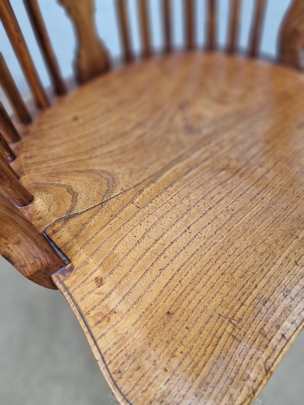 An early nineteenth-century Windsor armchair crafted from yew and elm, featuring a hoop back, pierced central splat, turned legs, and a curved crinoline stretcher. View XIII