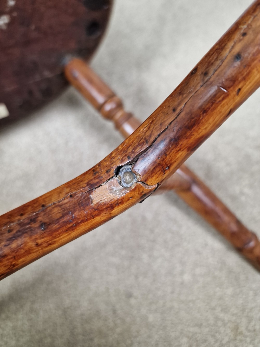 An early nineteenth-century Windsor armchair crafted from yew and elm, featuring a hoop back, pierced central splat, turned legs, and a curved crinoline stretcher. View XIV