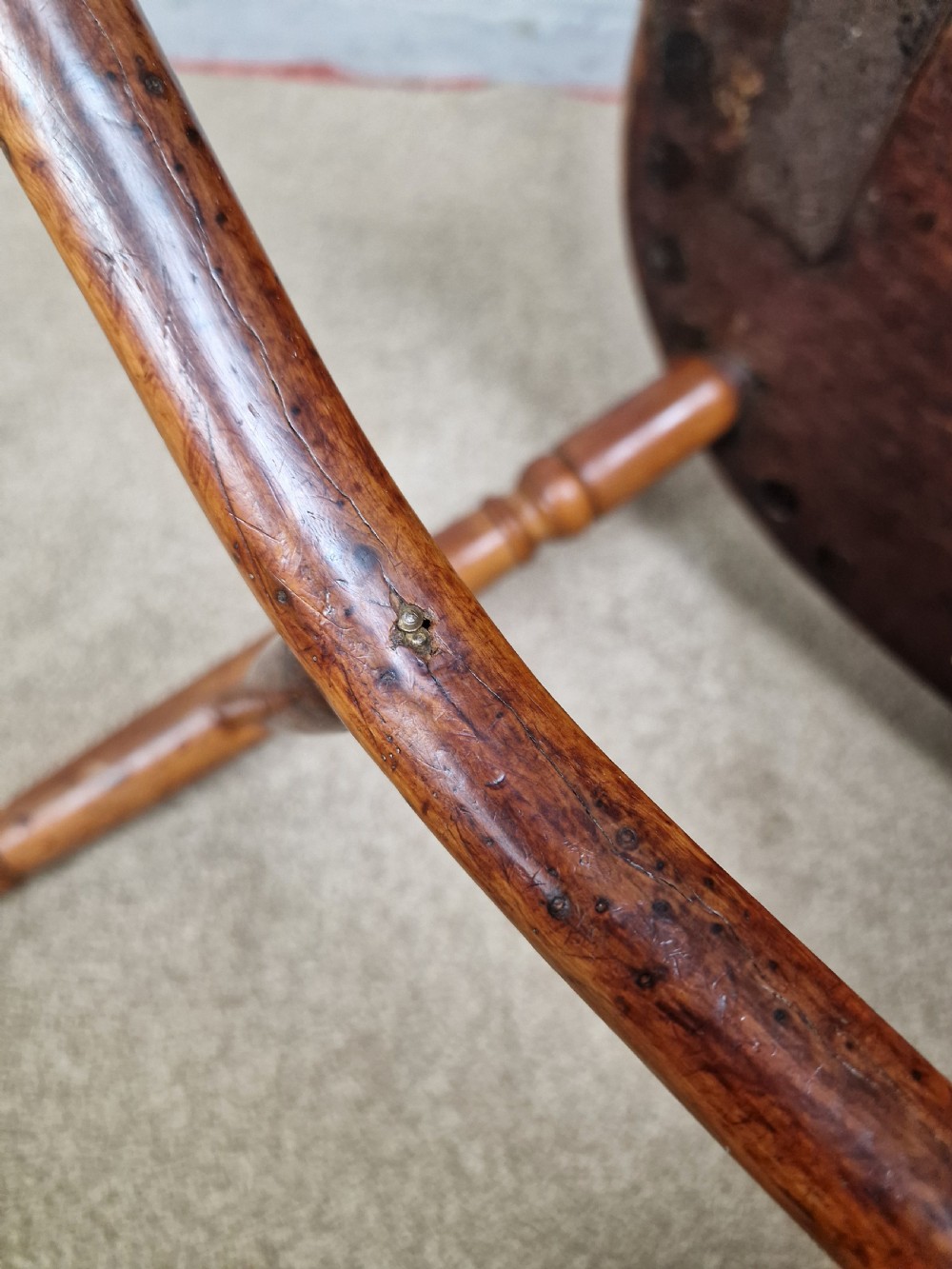 An early nineteenth-century Windsor armchair crafted from yew and elm, featuring a hoop back, pierced central splat, turned legs, and a curved crinoline stretcher. View XV