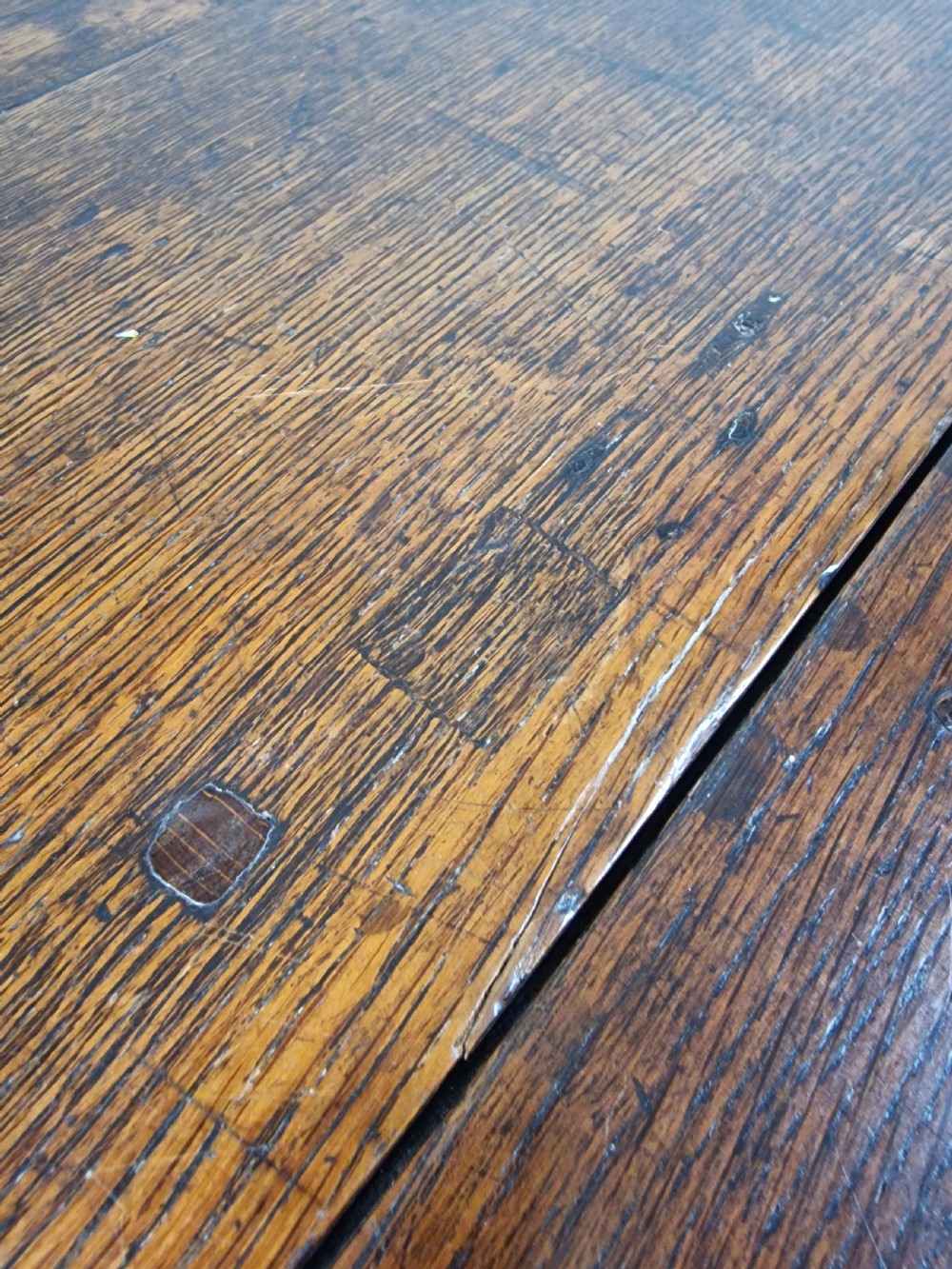 An 18th-century dark oak gateleg table featuring folded drop leaves, turned legs, and lower stretchers. View VII