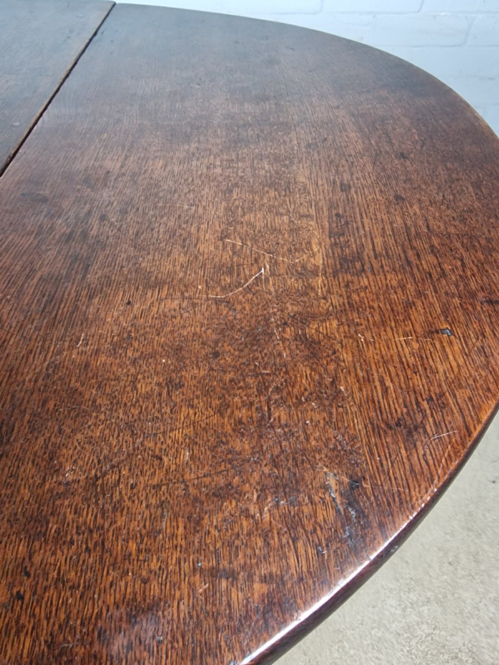 An 18th-century dark oak gateleg table featuring folded drop leaves, turned legs, and lower stretchers. View XI