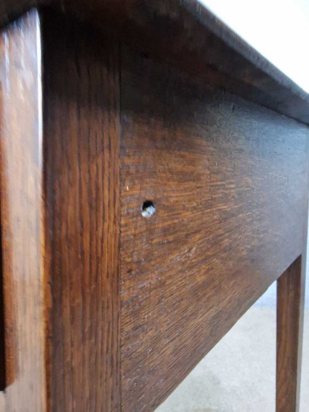 An 18th-century antique oak lowboy side table featuring a single wide drawer with brass handles and square tapered legs. View IV