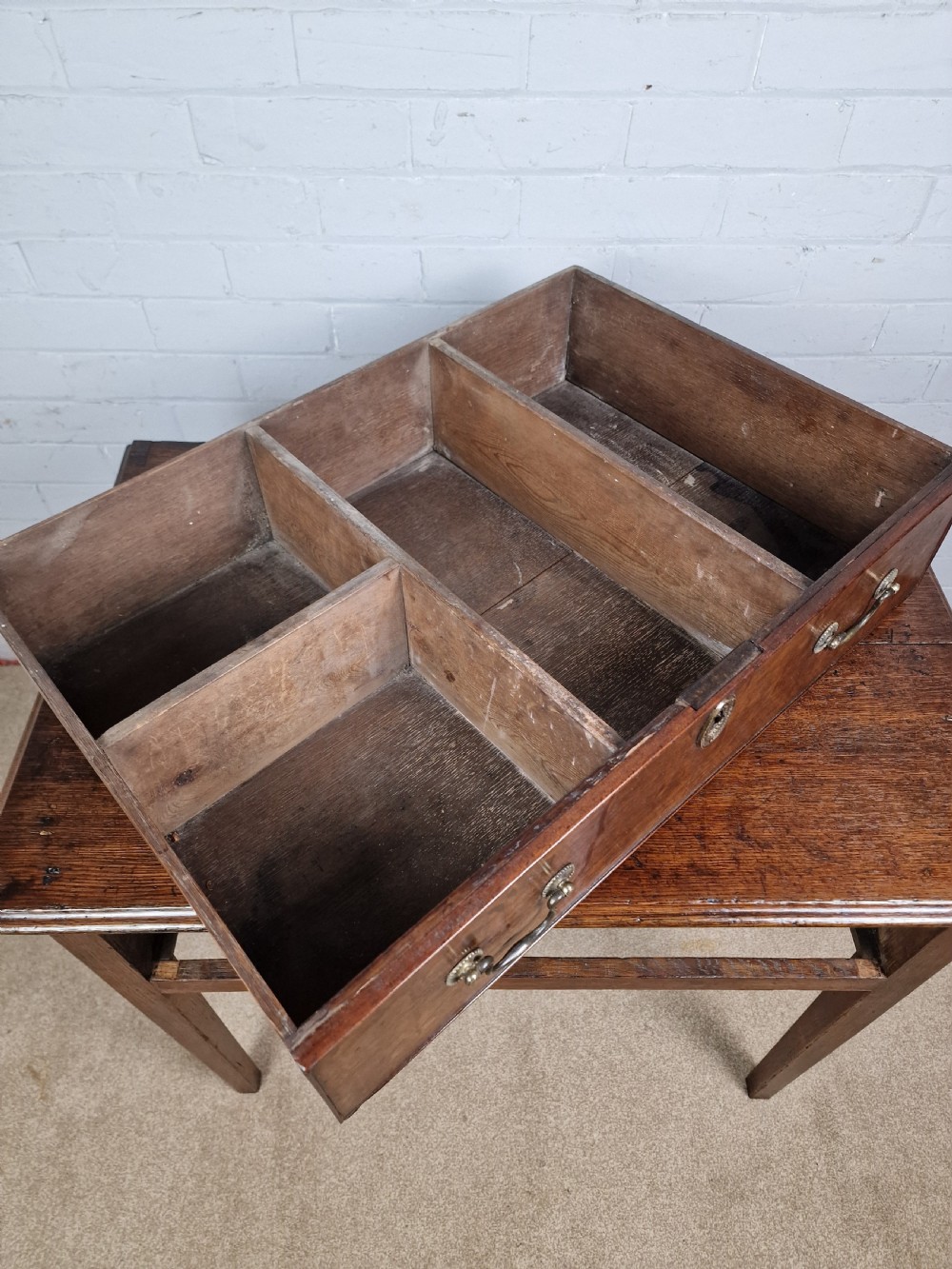 An 18th-century antique oak lowboy side table featuring a single wide drawer with brass handles and square tapered legs. View VII