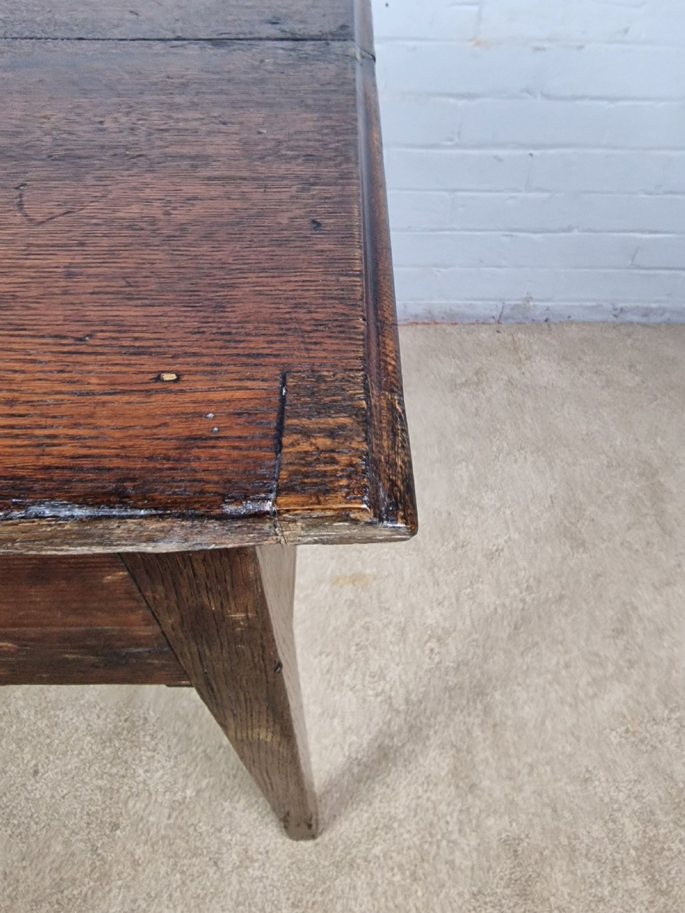 An 18th-century antique oak lowboy side table featuring a single wide drawer with brass handles and square tapered legs. View IX