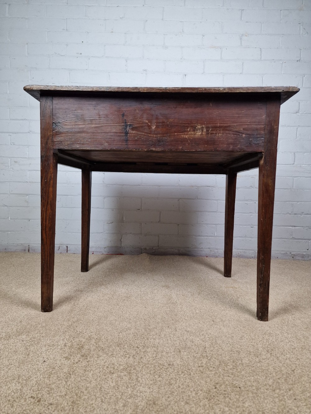 An 18th-century antique oak lowboy side table featuring a single wide drawer with brass handles and square tapered legs. View X