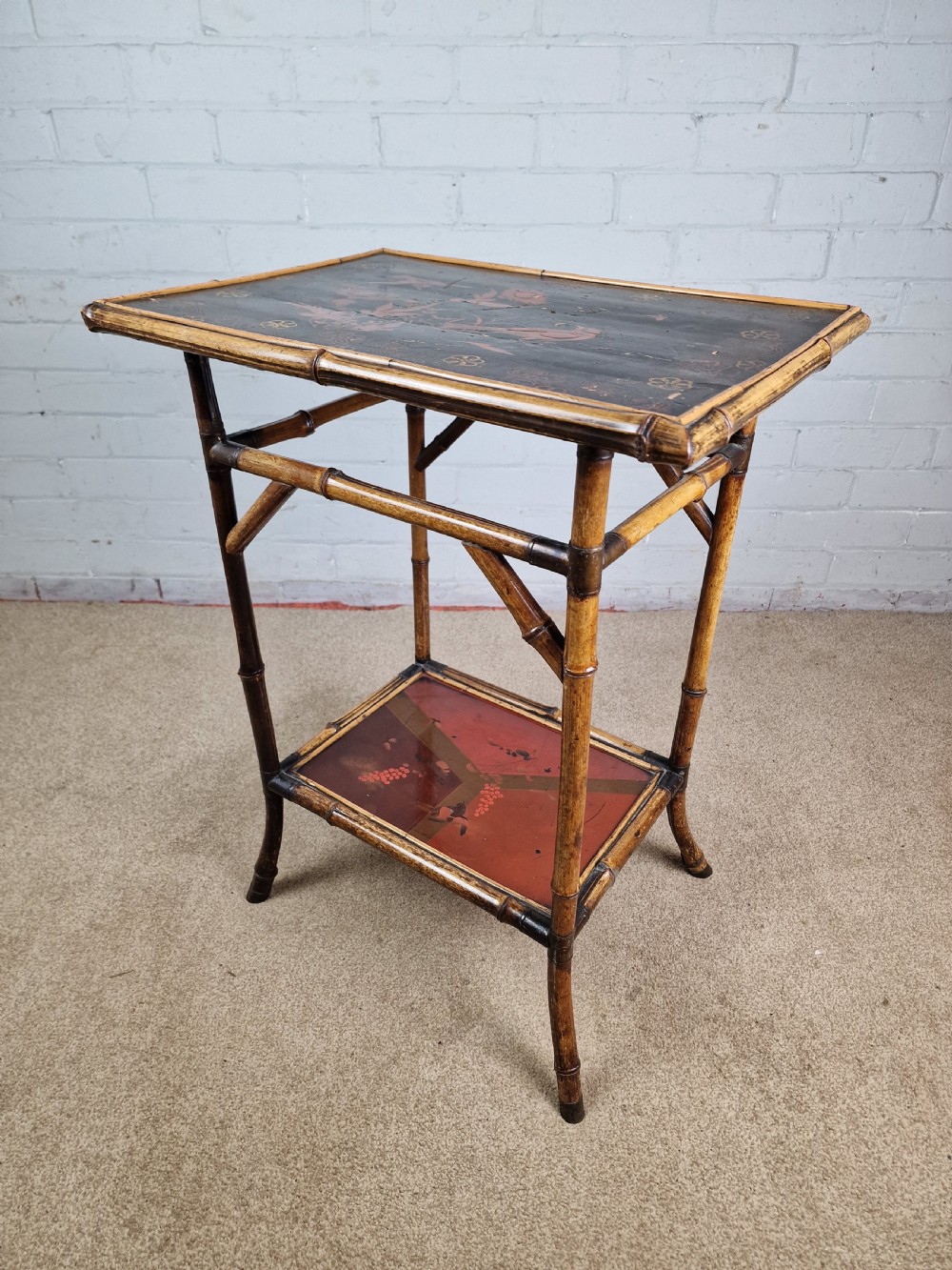 A 19th-century Aesthetic Movement side table crafted from bamboo with a dark lacquered top panel featuring floral hand-painted details and an undertier. View III