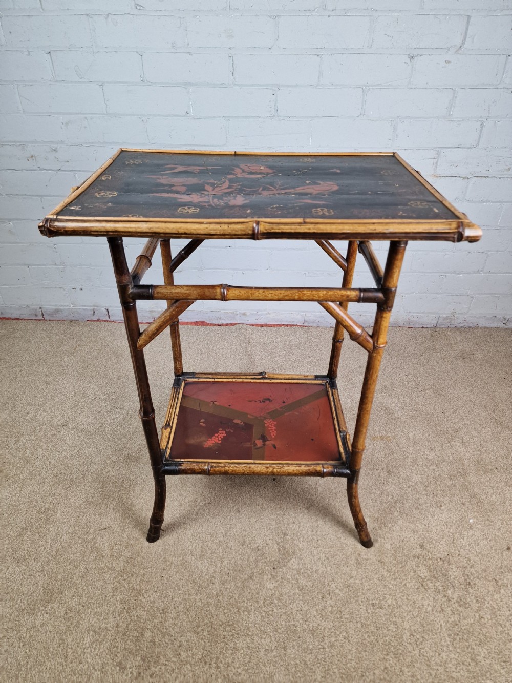 A 19th-century Aesthetic Movement side table crafted from bamboo with a dark lacquered top panel featuring floral hand-painted details and an undertier. View IV