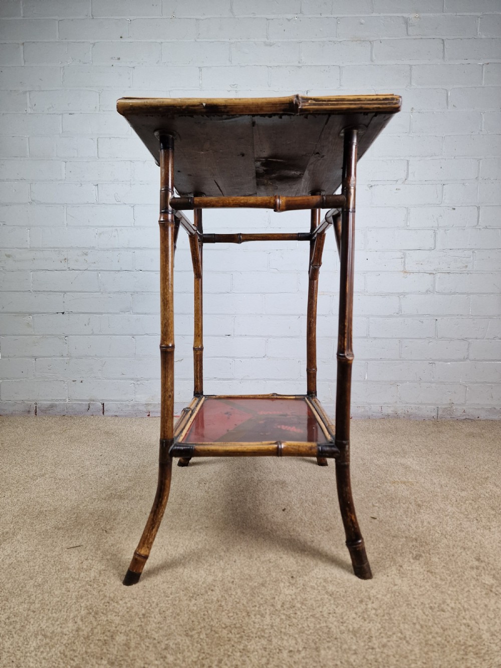 A 19th-century Aesthetic Movement side table crafted from bamboo with a dark lacquered top panel featuring floral hand-painted details and an undertier. View VI