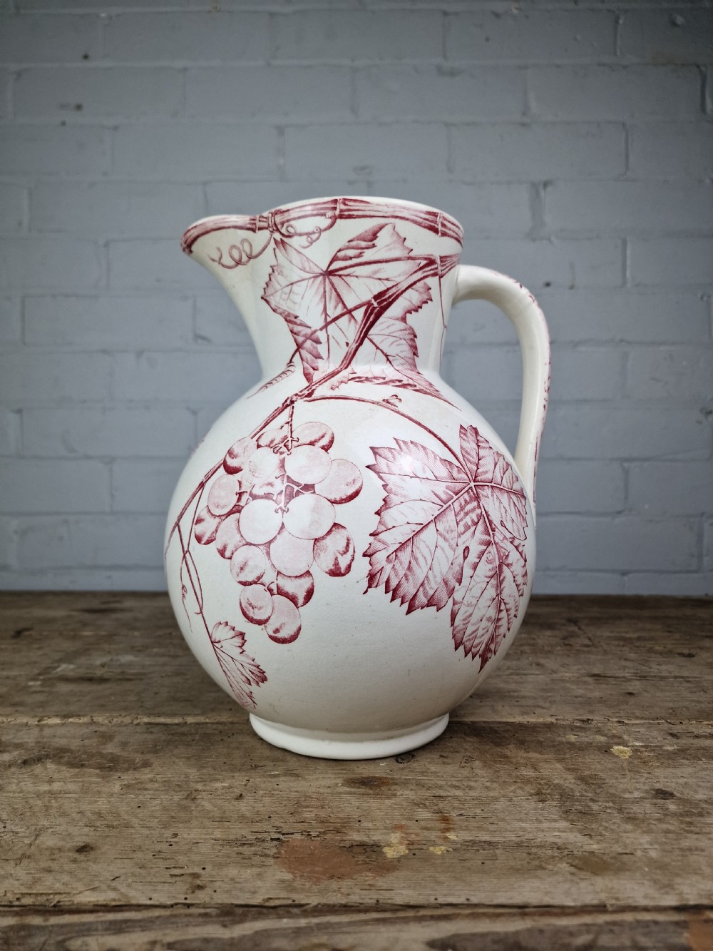 A Victorian cream ceramic jug decorated with a red transferware pattern of grapes and vine leaves. View XII