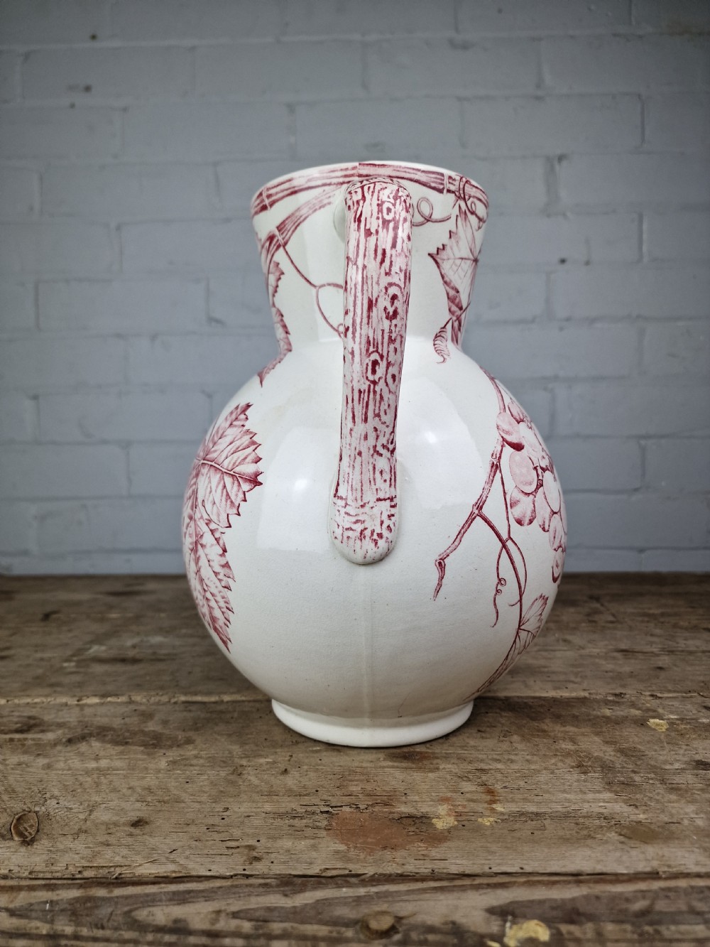 A Victorian cream ceramic jug decorated with a red transferware pattern of grapes and vine leaves. View VII