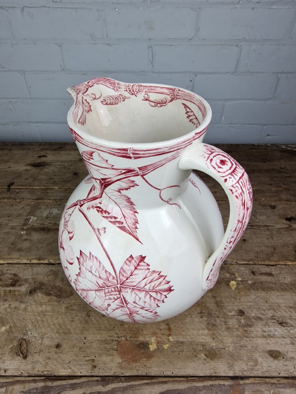 A Victorian cream ceramic jug decorated with a red transferware pattern of grapes and vine leaves. View VIII