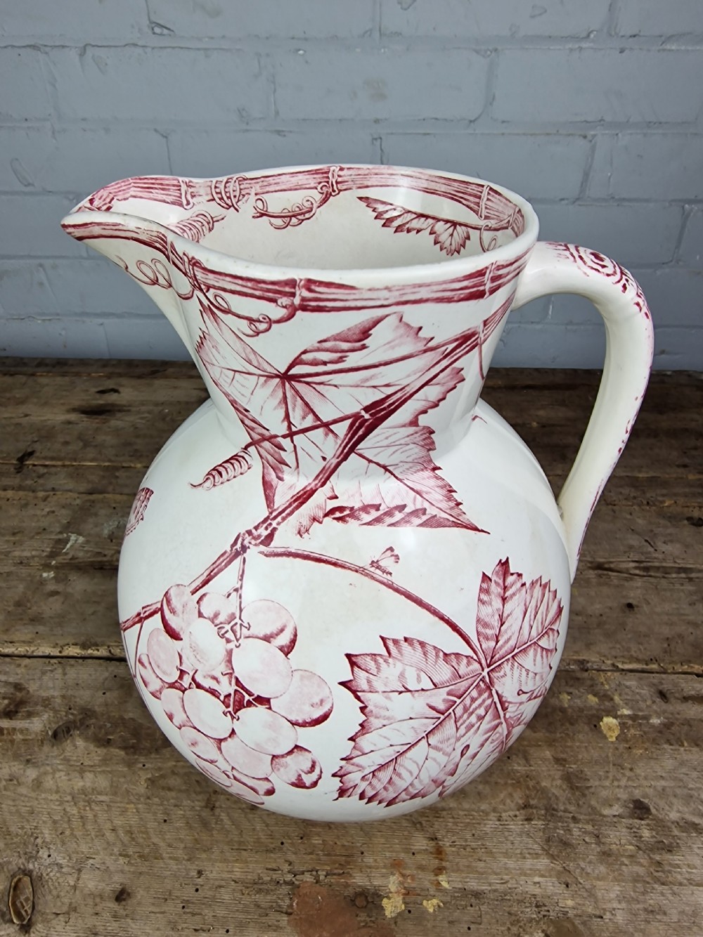 A Victorian cream ceramic jug decorated with a red transferware pattern of grapes and vine leaves. View XI