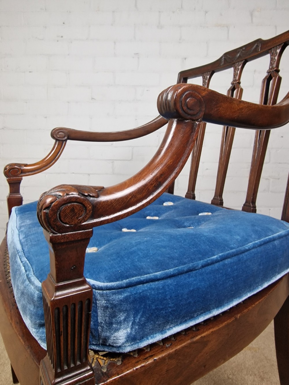A Georgian mahogany open armchair featuring carved splats, curved arms, tapered fluted front legs, and a padded blue velvet cushion seat. View XIII