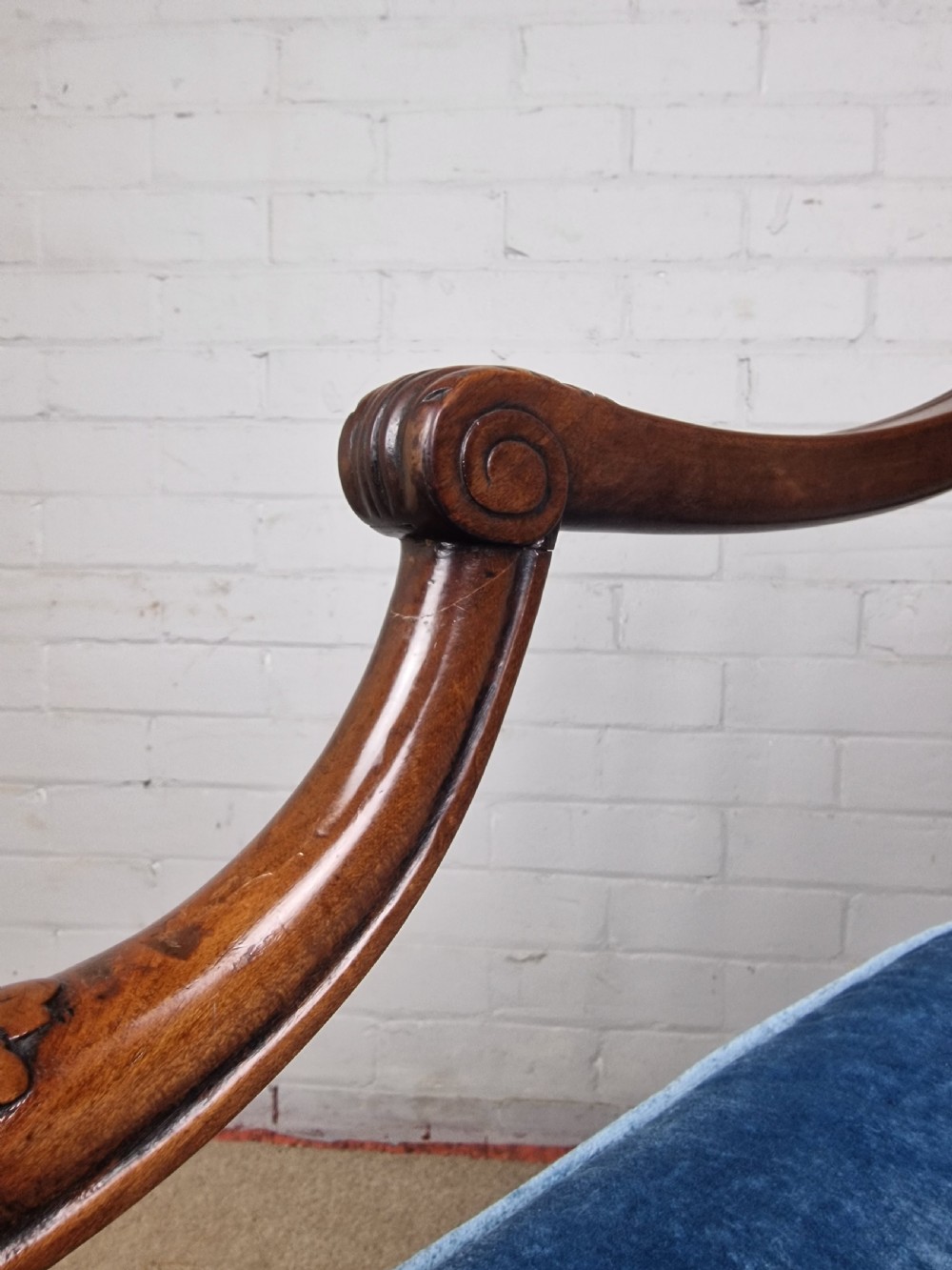 A Georgian mahogany open armchair featuring carved splats, curved arms, tapered fluted front legs, and a padded blue velvet cushion seat. View XV