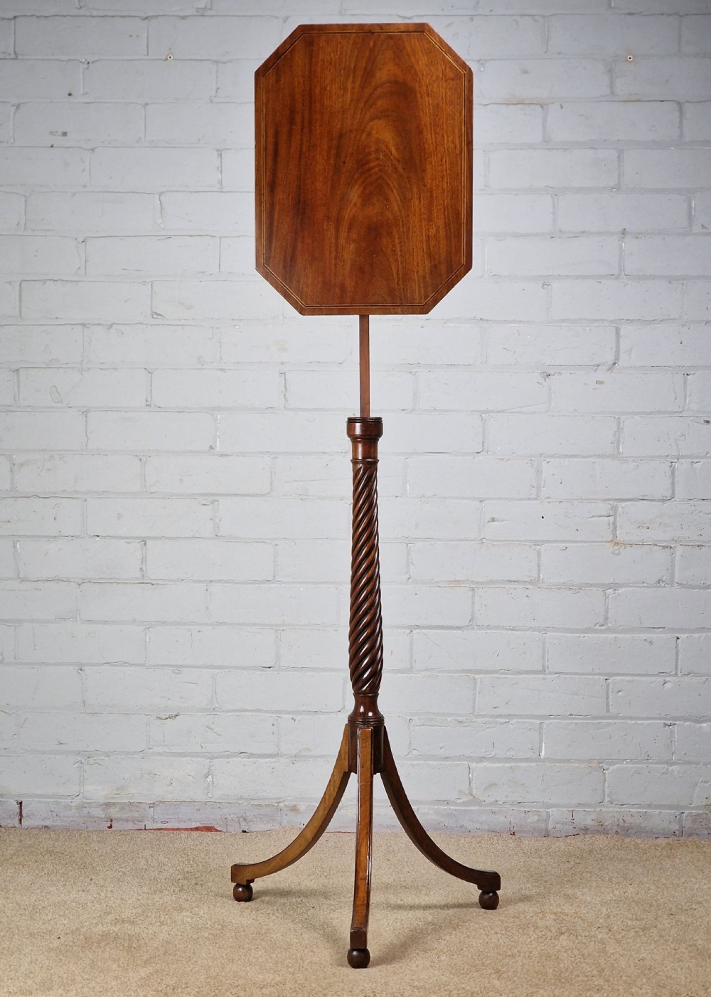 An early nineteenth-century Regency mahogany tripod table featuring an octagonal top with boxwood stringing, a spiral-turned stem, and downcurved tripod legs. View IV