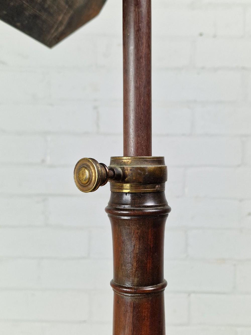 An early 19th-century Regency mahogany reading table featuring an octagonal inlaid tilt top with a raised book lip, supported by a turned column on tripod legs. View V
