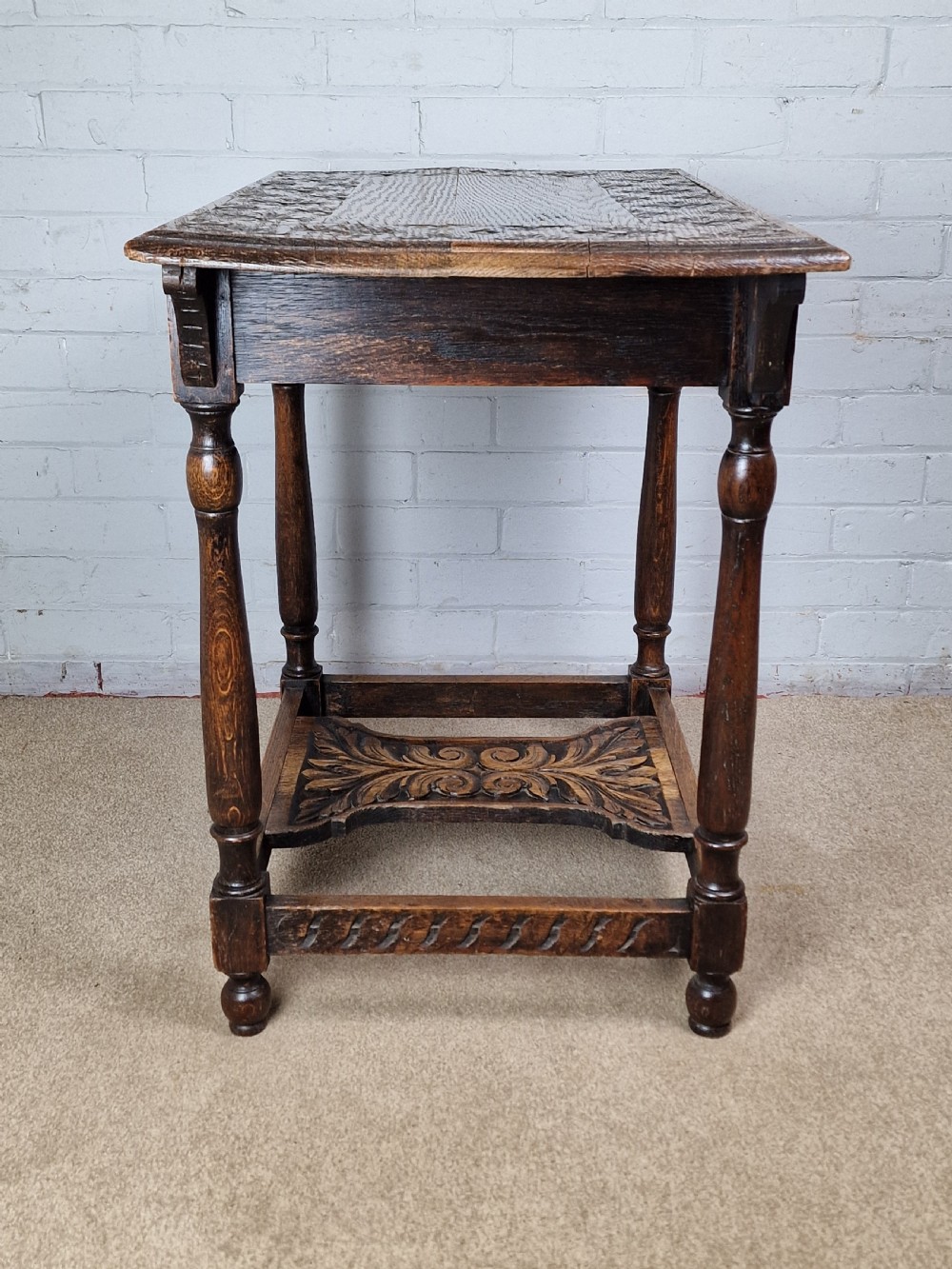 A late Victorian rectangular side table in carved brown oak, featuring a floral border top, lunette carved apron, turned legs, and a carved lower stretcher. View III