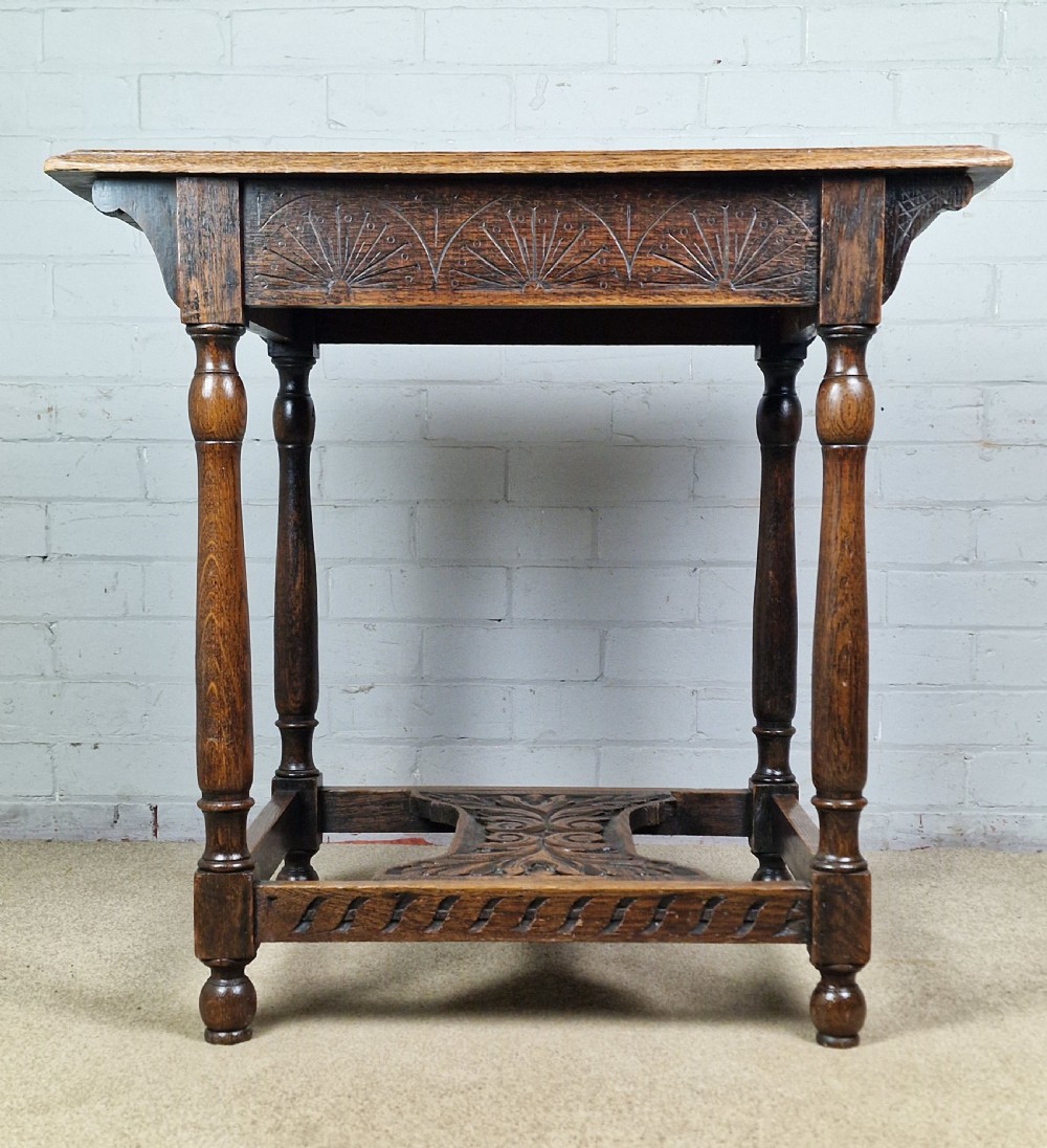 A late Victorian rectangular side table in carved brown oak, featuring a floral border top, lunette carved apron, turned legs, and a carved lower stretcher. View VIII