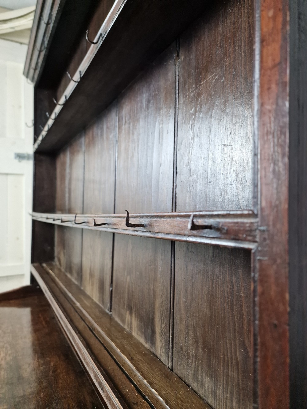 An 18th-century George II oak dresser featuring a top open plate rack above three frieze drawers and an open lower pot shelf. View X