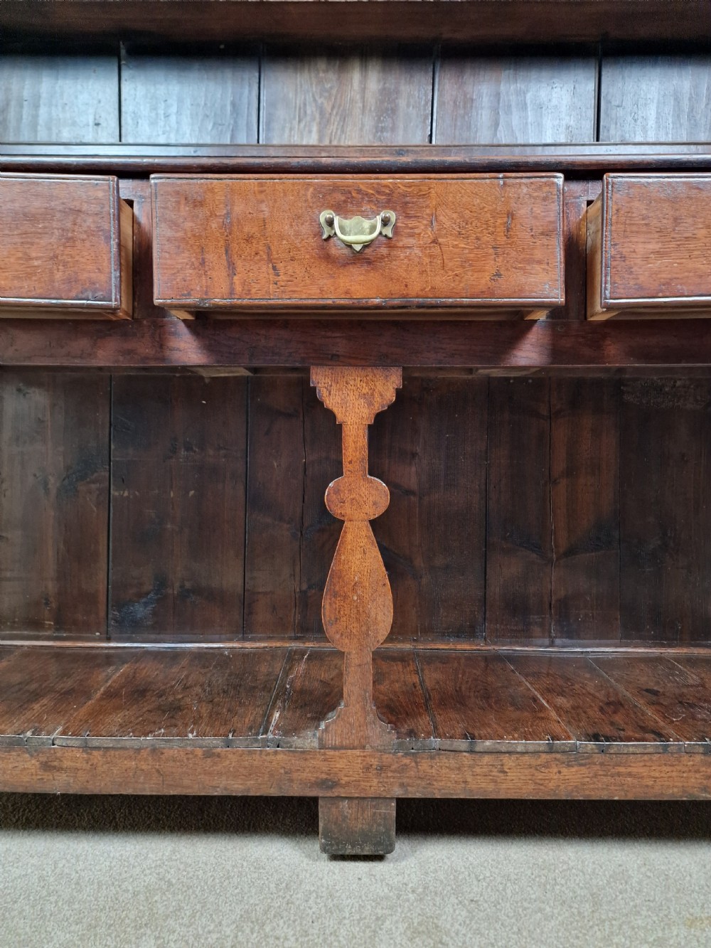 An 18th-century George II oak dresser featuring a top open plate rack above three frieze drawers and an open lower pot shelf. View IV