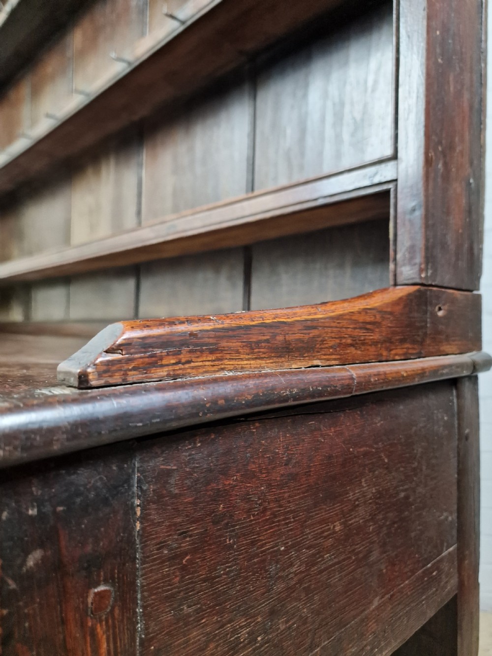 An 18th-century George II oak dresser featuring a top open plate rack above three frieze drawers and an open lower pot shelf. View V