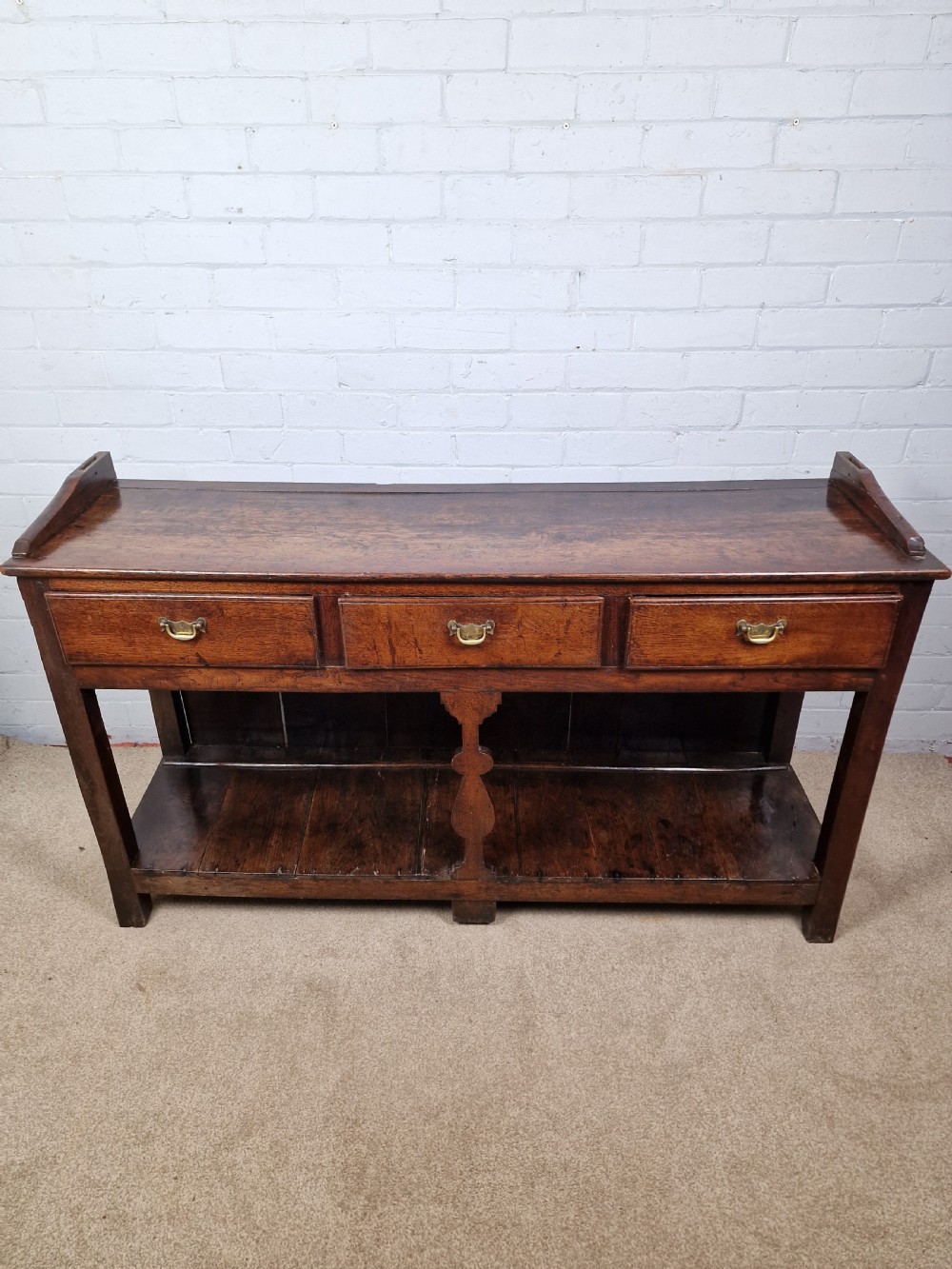 An 18th-century George II oak dresser featuring a top open plate rack above three frieze drawers and an open lower pot shelf. View VIII