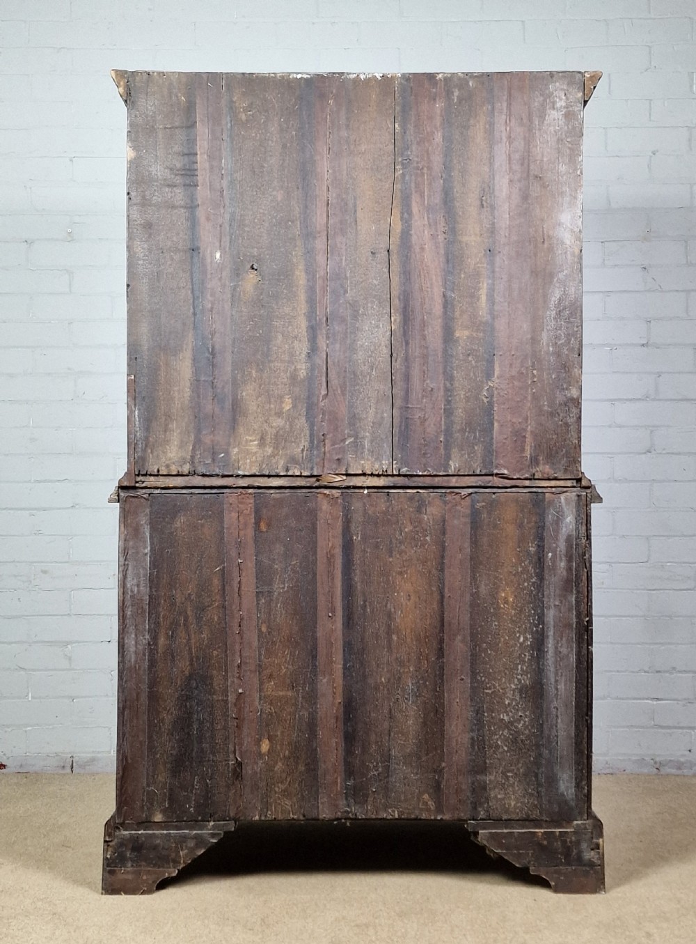An early eighteenth-century Georgian walnut secretaire chest on chest featuring brass drop handles, a drop-front desk compartment with fitted pigeonholes, and bracket feet. View VIII