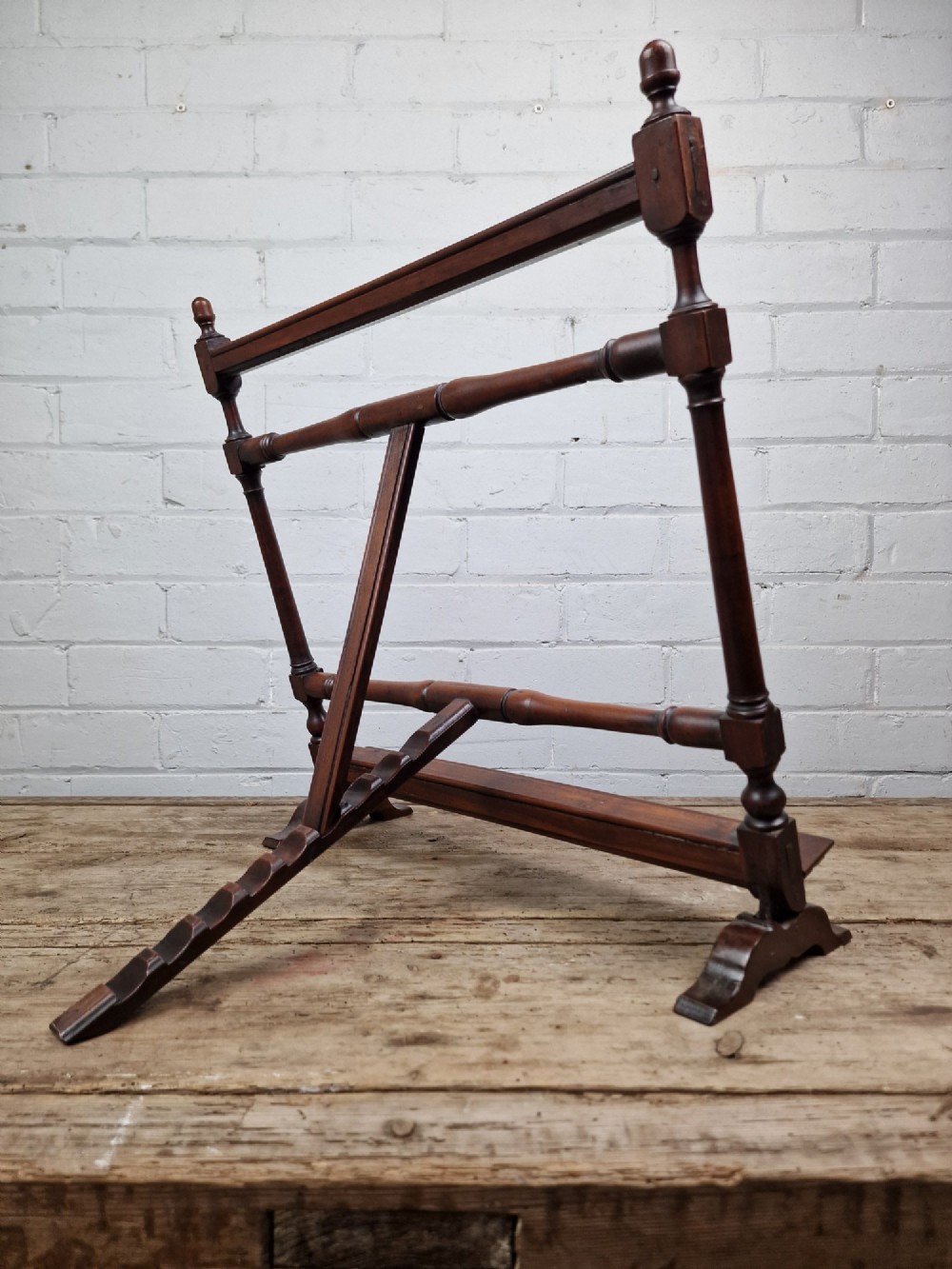 A nineteenth-century mahogany table-top easel featuring turned wooden side supports, finials, a front shelf ledge, and an adjustable rear prop stand. View VI