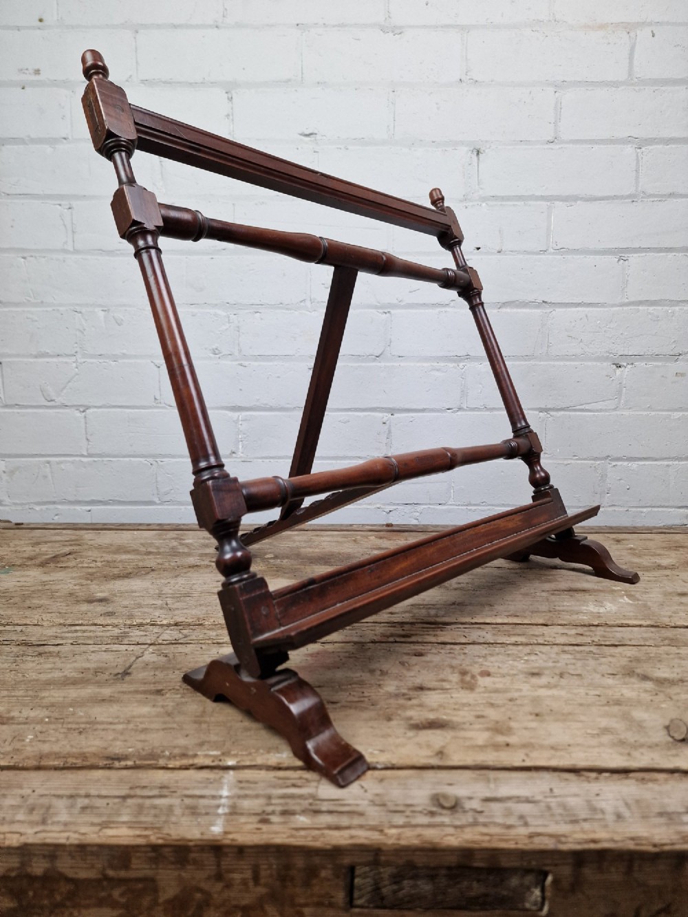 A nineteenth-century mahogany table-top easel featuring turned wooden side supports, finials, a front shelf ledge, and an adjustable rear prop stand.