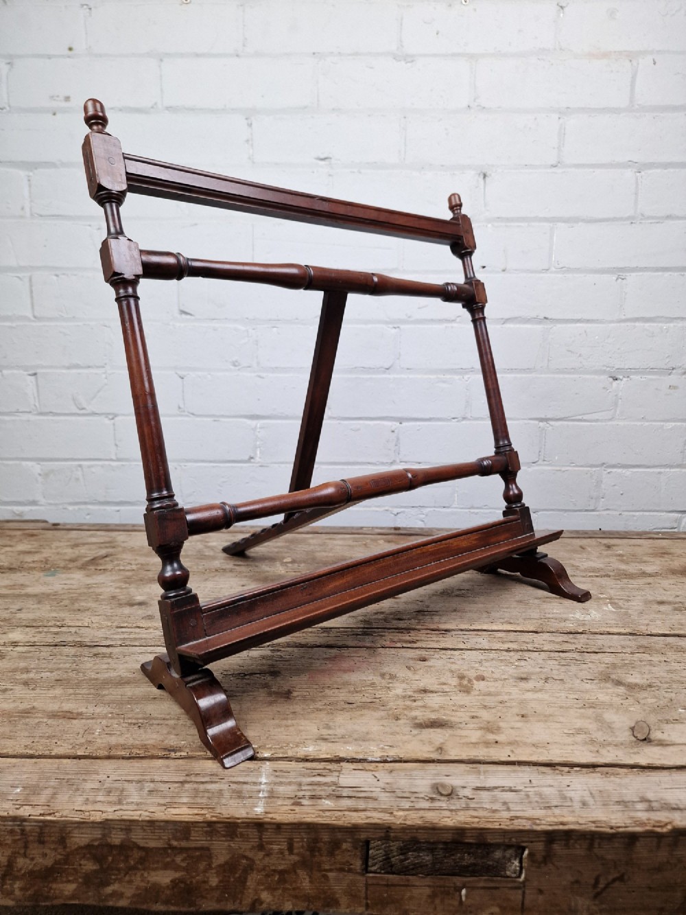 A nineteenth-century mahogany table-top easel featuring turned wooden side supports, finials, a front shelf ledge, and an adjustable rear prop stand. View X