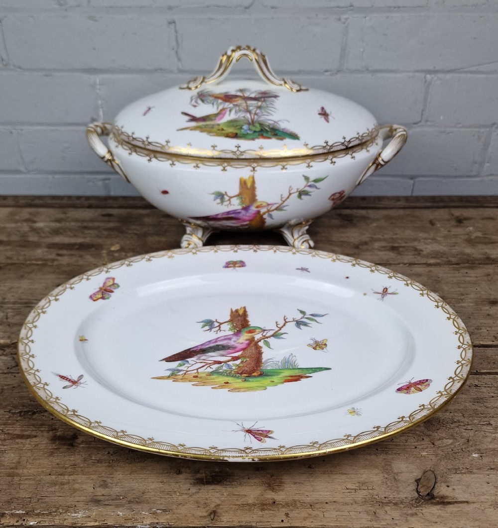 An antique white porcelain soup tureen featuring hand-painted bird motifs, gilded scroll handles, four scroll feet, and a matching underplate. View XIV