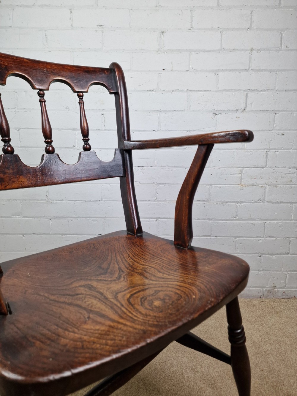 A Victorian dark brown elm and beech Oxford bar back Windsor armchair featuring turned spindles, shaped armrests, and turned legs with stretchers. View IV
