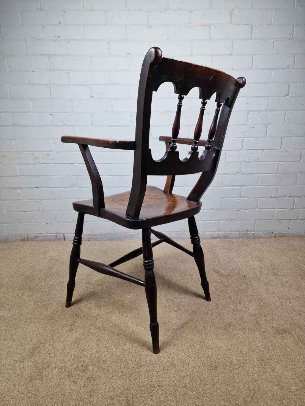 A Victorian dark brown elm and beech Oxford bar back Windsor armchair featuring turned spindles, shaped armrests, and turned legs with stretchers. View VII