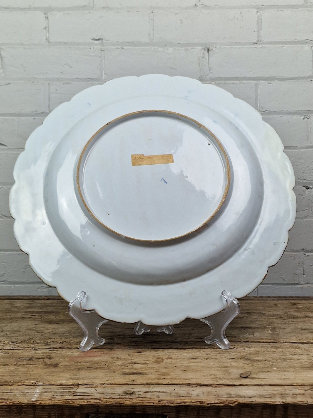 An 18th-century English Delftware charger featuring cobalt blue chinoiserie landscape hand-painted on a white scalloped earthenware platter. View IV