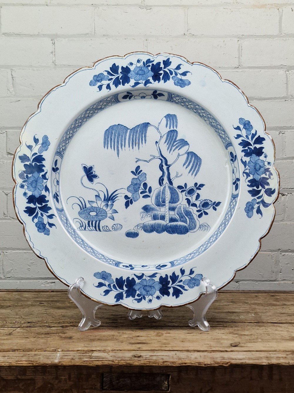 An 18th-century English Delftware charger featuring cobalt blue chinoiserie landscape hand-painted on a white scalloped earthenware platter. View VI