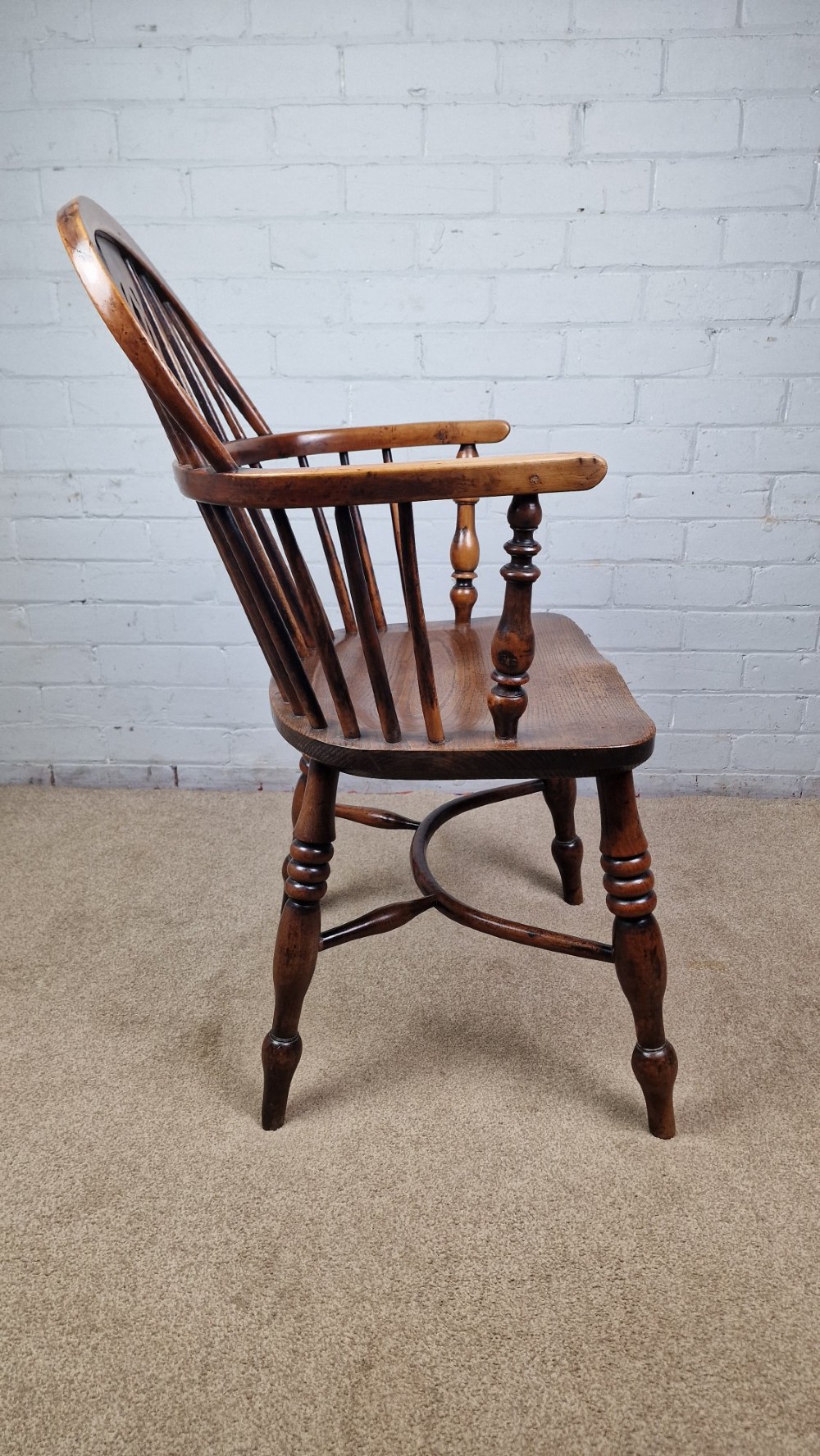 A 19th-century Nottinghamshire Windsor armchair featuring a hoop back with a pierced splat, shaped elm saddle seat, steam-bent yew bow, and turned legs. View II