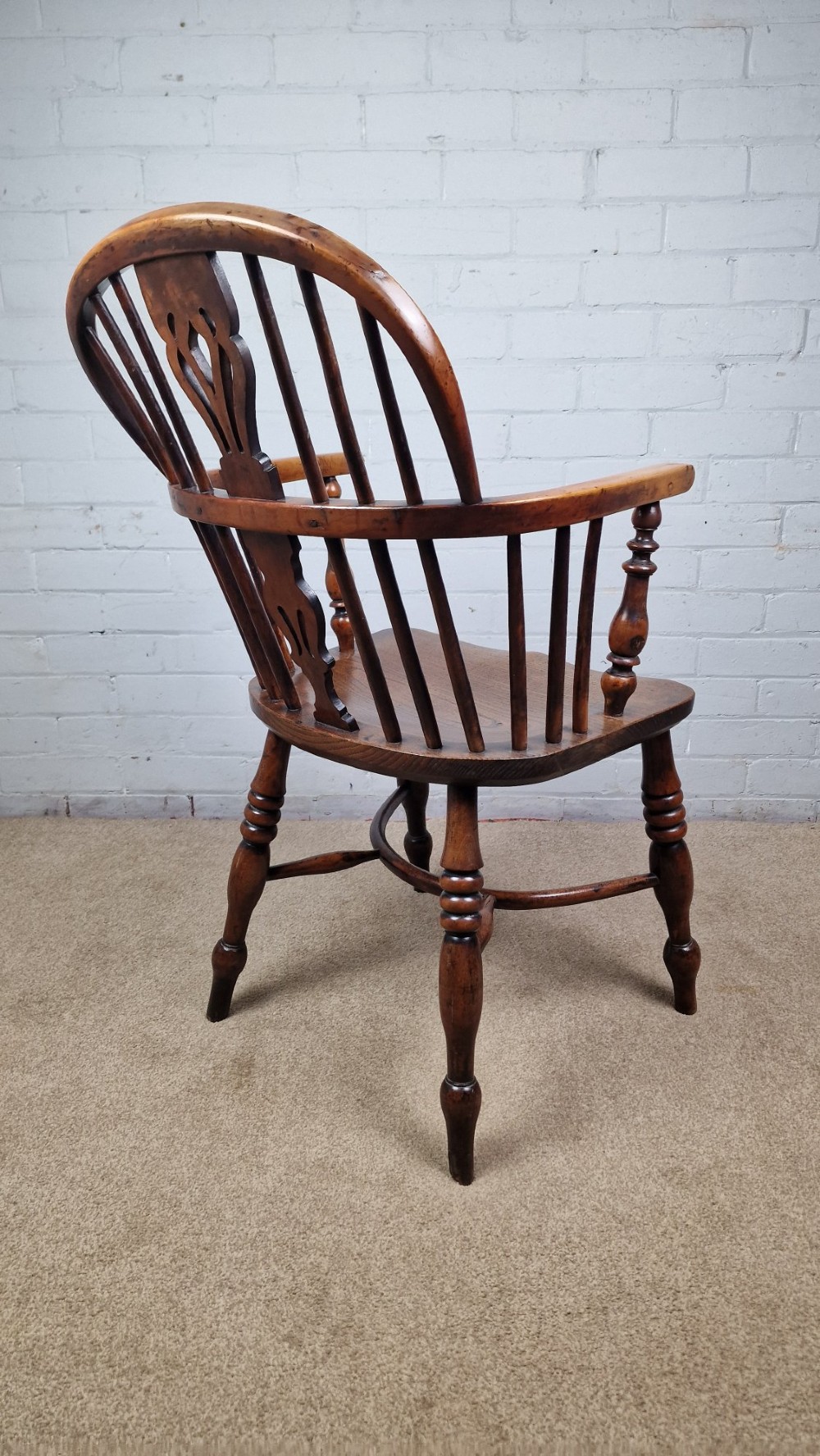 A 19th-century Nottinghamshire Windsor armchair featuring a hoop back with a pierced splat, shaped elm saddle seat, steam-bent yew bow, and turned legs. View III