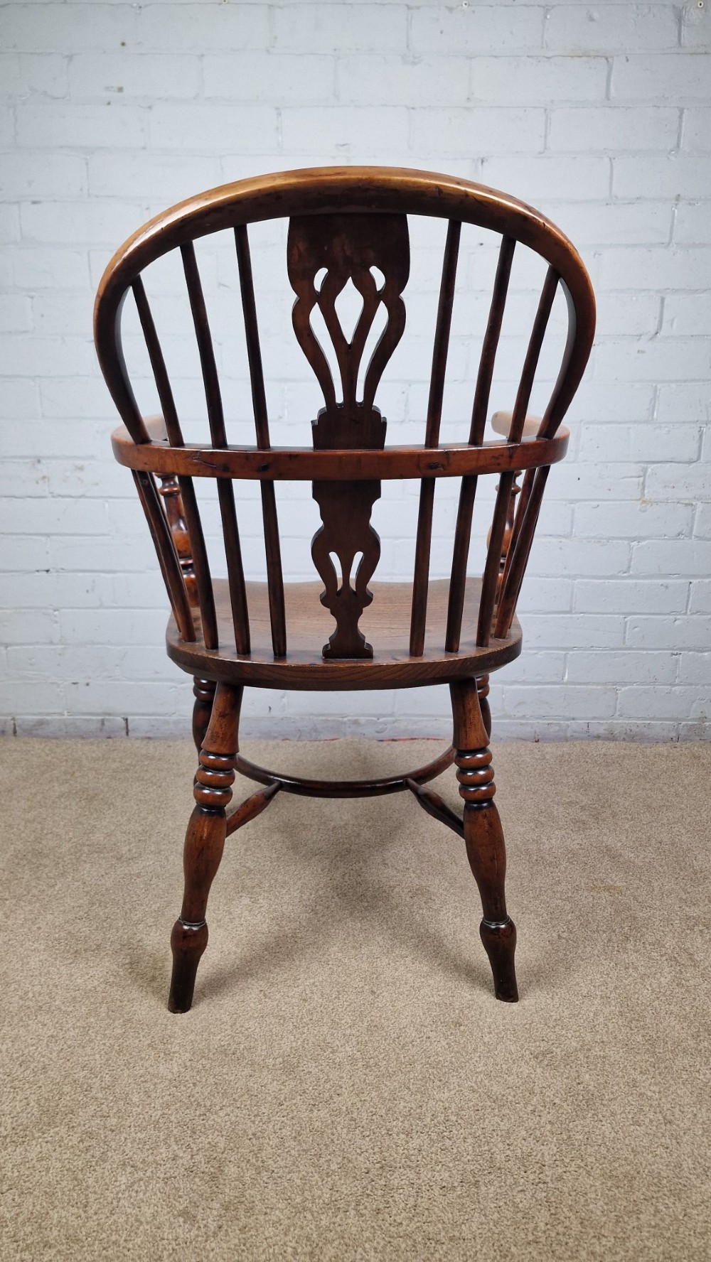 A 19th-century Nottinghamshire Windsor armchair featuring a hoop back with a pierced splat, shaped elm saddle seat, steam-bent yew bow, and turned legs. View IV