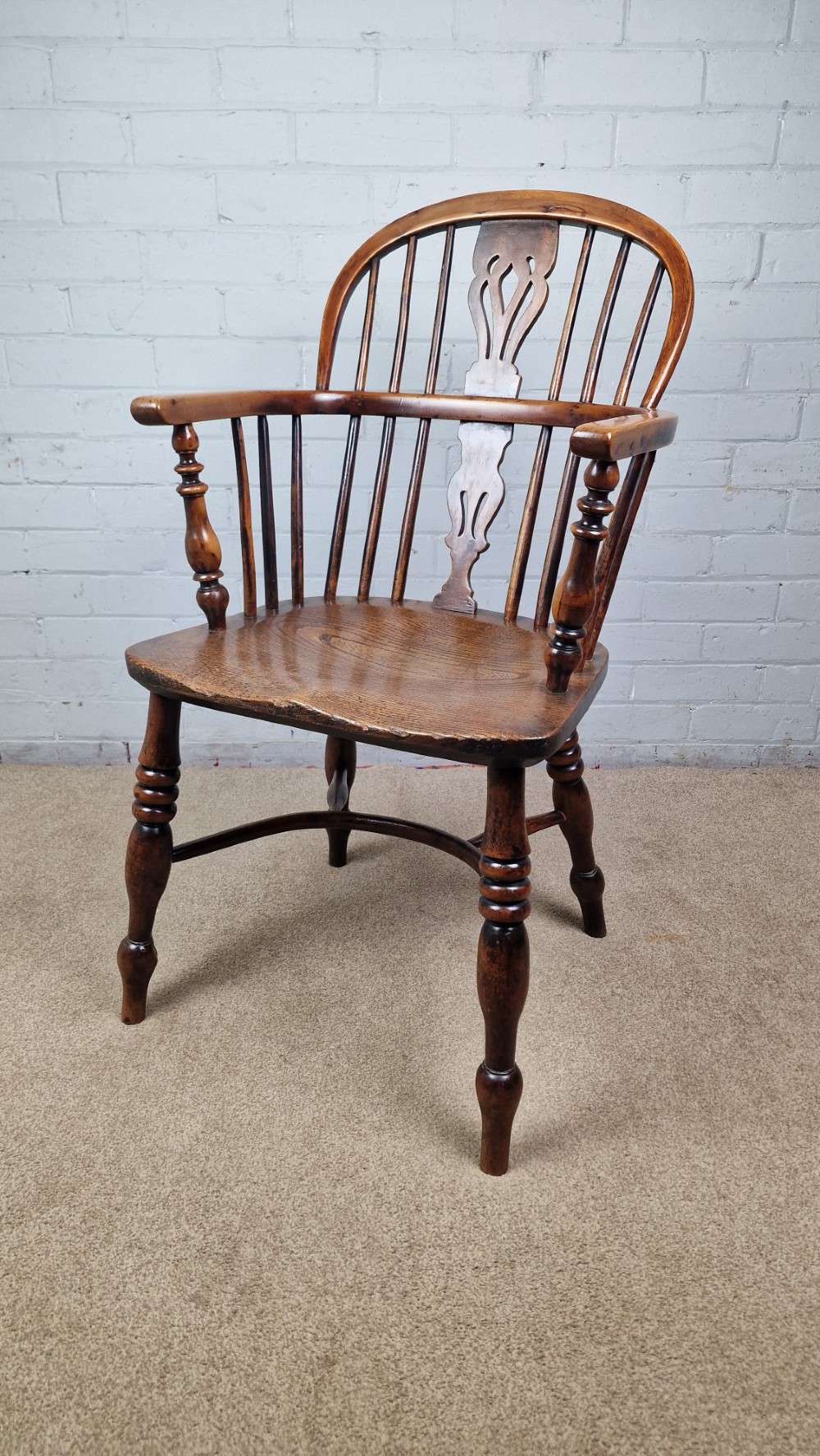 A 19th-century Nottinghamshire Windsor armchair featuring a hoop back with a pierced splat, shaped elm saddle seat, steam-bent yew bow, and turned legs. View VIII