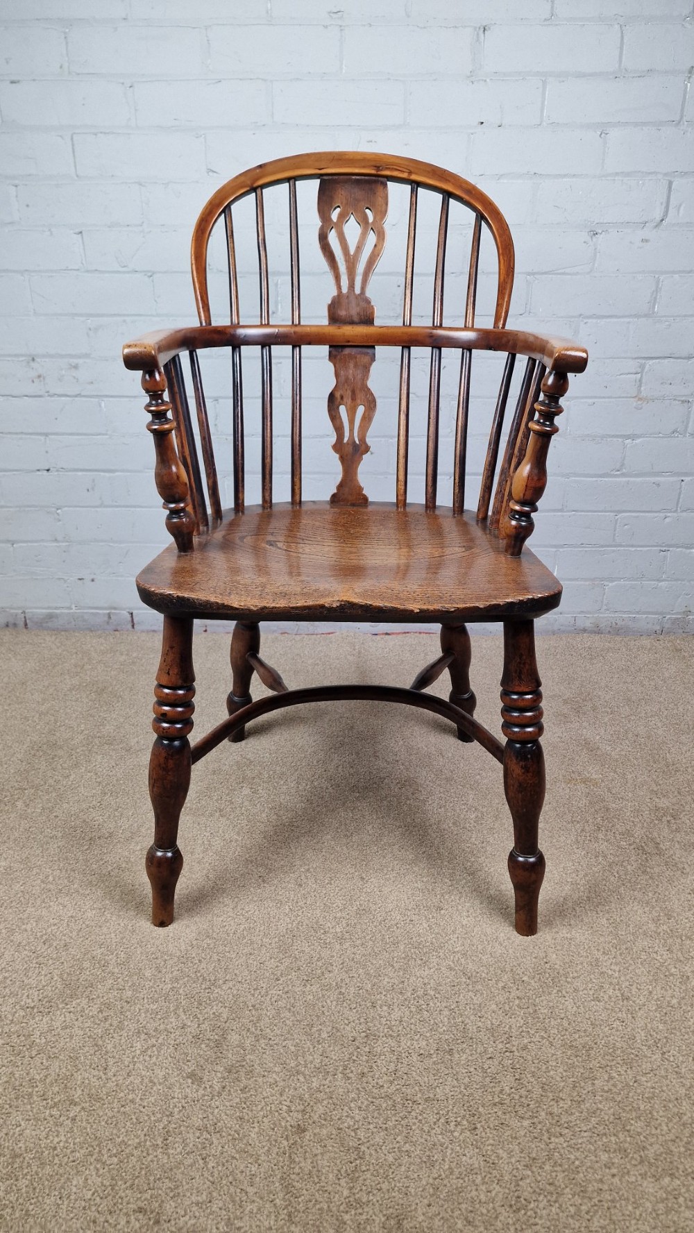 A 19th-century Nottinghamshire Windsor armchair featuring a hoop back with a pierced splat, shaped elm saddle seat, steam-bent yew bow, and turned legs. View IX