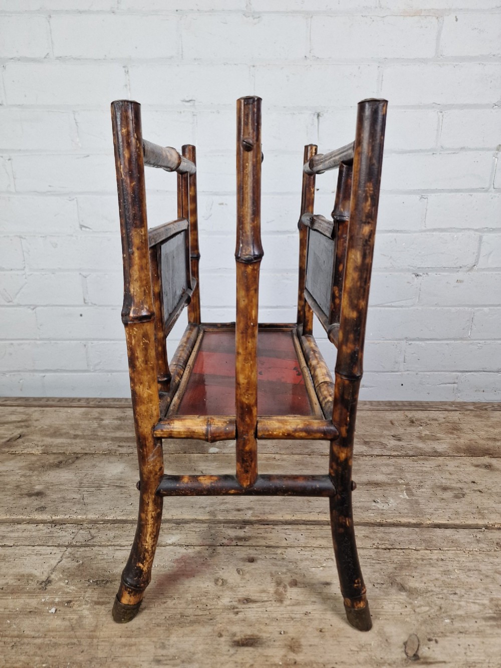 A nineteenth-century tiger bamboo magazine rack featuring a mottled cane frame with lacquered side panels. View III