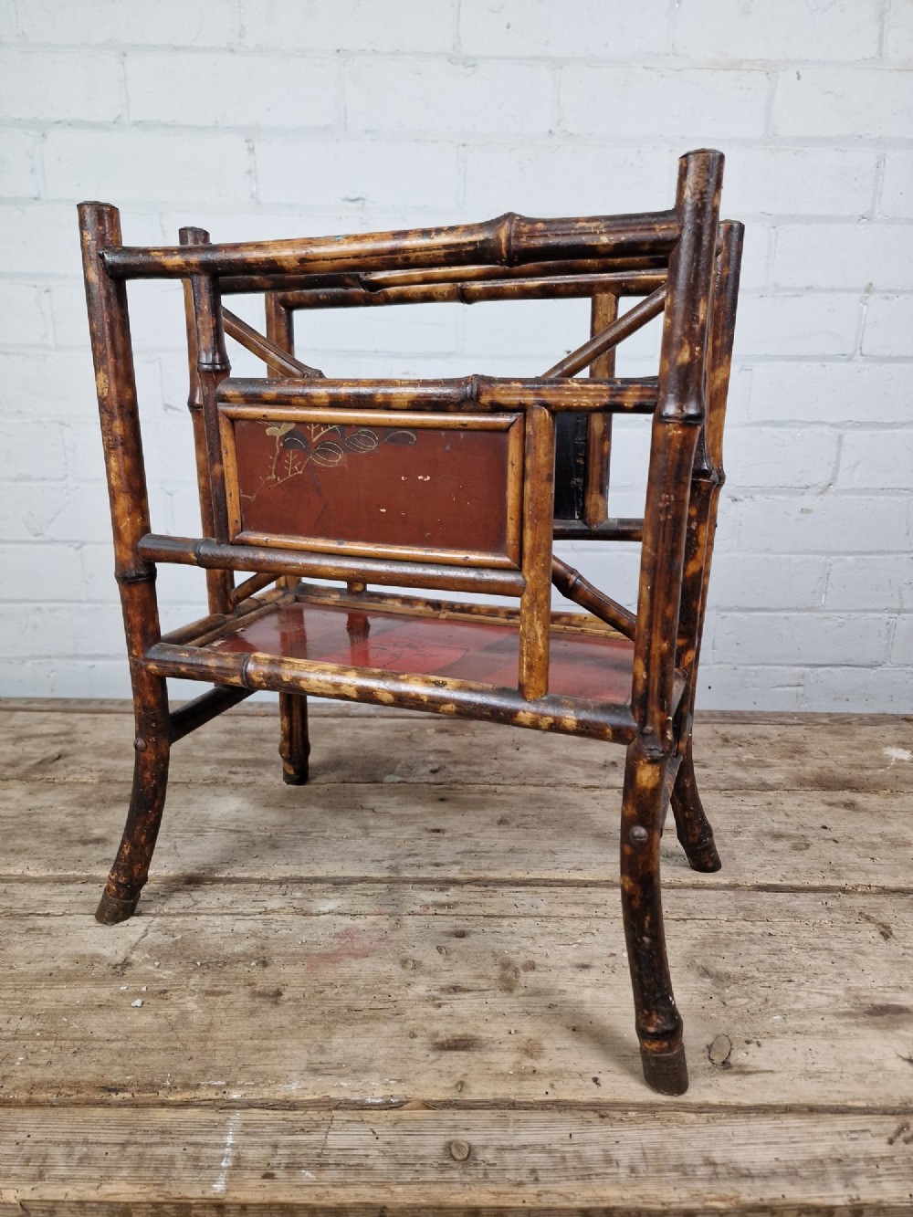 A nineteenth-century tiger bamboo magazine rack featuring a mottled cane frame with lacquered side panels. View VI