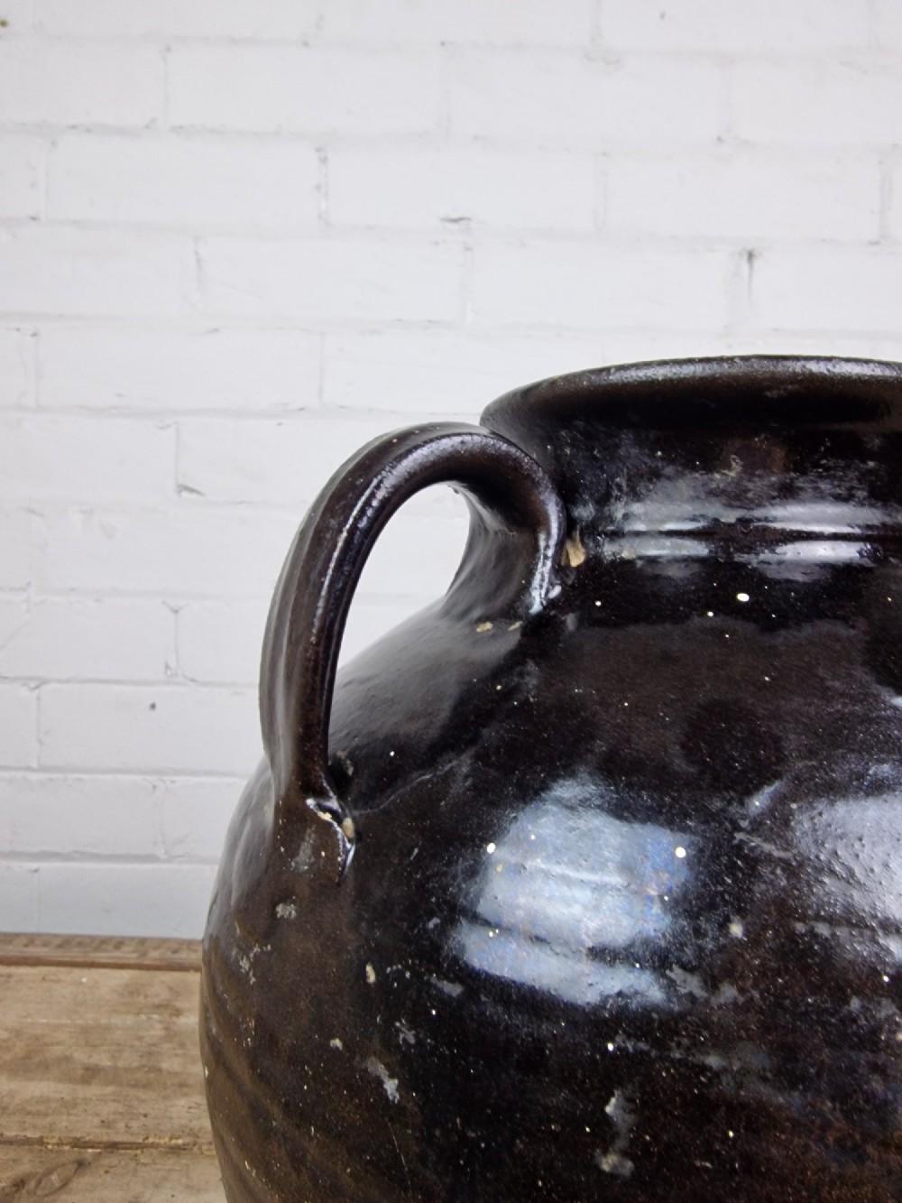 An antique late 18th or early 19th-century earthenware slipware jug featuring a dark brown glazed upper body and a textured terracotta lower base. View VII