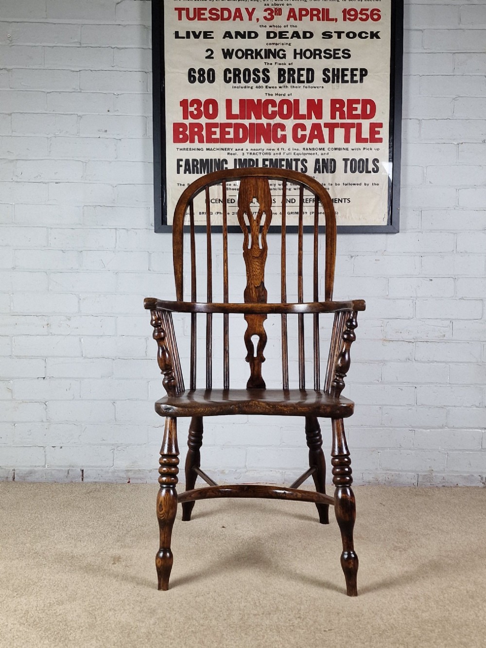 A 19th-century dark wooden Lincolnshire Windsor armchair featuring a hoop back, central pierced splat, turned spindles, and turned legs. View III