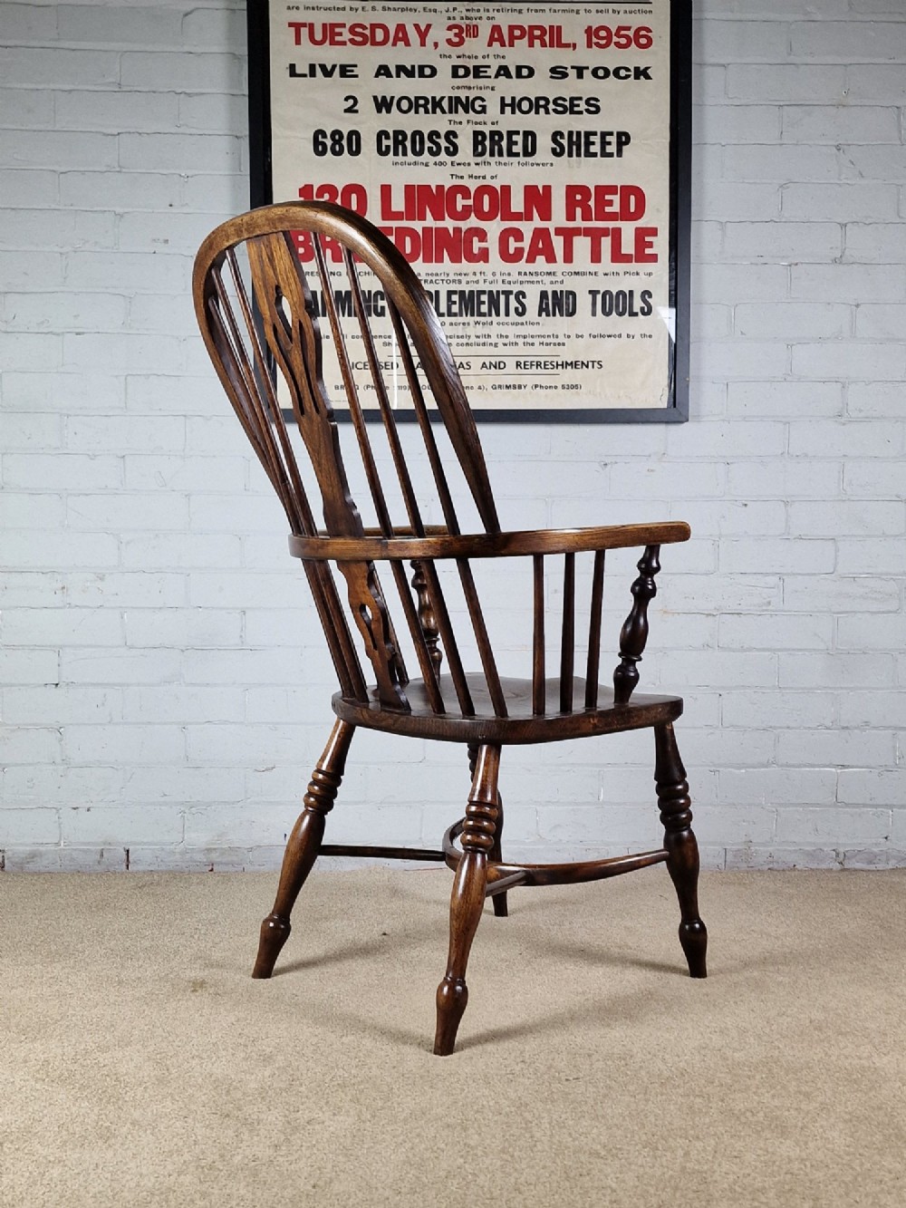 A 19th-century dark wooden Lincolnshire Windsor armchair featuring a hoop back, central pierced splat, turned spindles, and turned legs. View IV