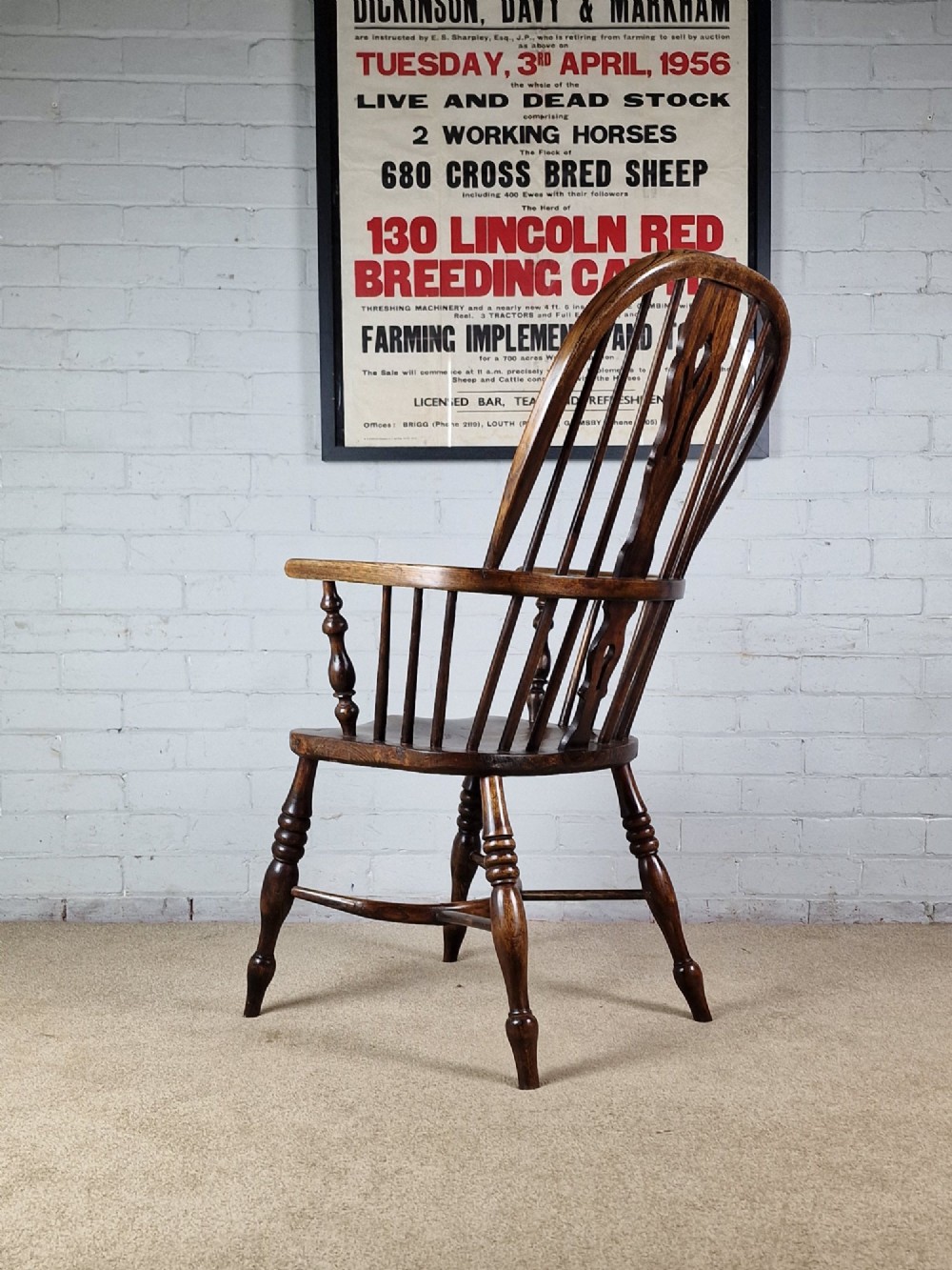 A 19th-century dark wooden Lincolnshire Windsor armchair featuring a hoop back, central pierced splat, turned spindles, and turned legs. View V